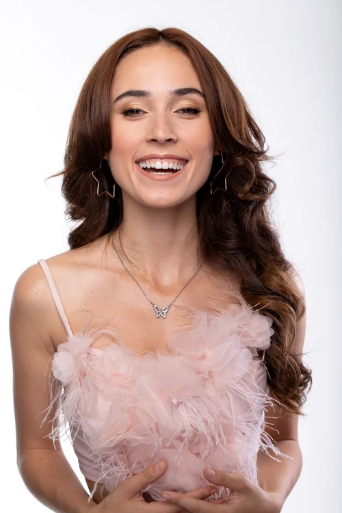 Andra Gogan zâmbind îmbrăcată într-o rochie roz