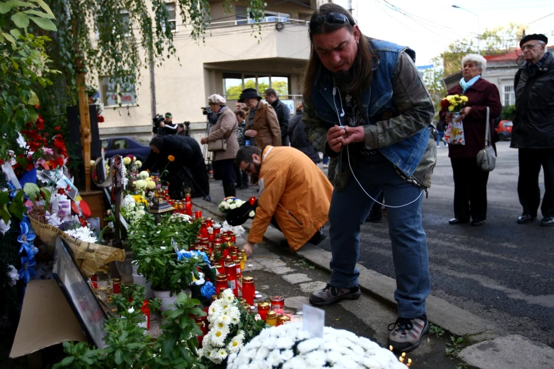 oameni care aprind lumanari in fata clubului colectiv