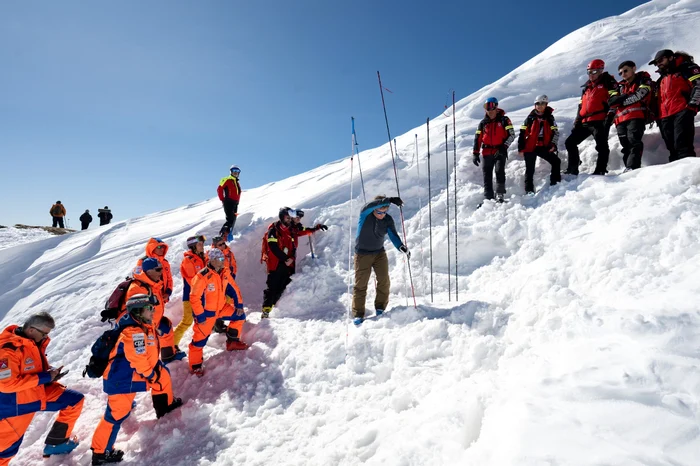 Salvamontiști români și italieni exersând căutarea victimelor prinse de avalanșă