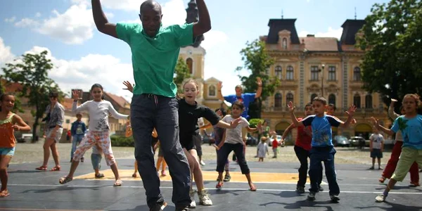 Bouba Landrille Tchouda le arată câteva mișcări de dans copiilor. Foto: Sebastian Tătaru