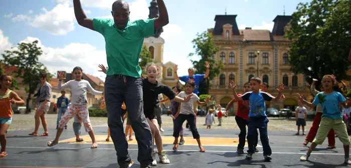 Bouba Landrille Tchouda le arată câteva mișcări de dans copiilor. Foto: Sebastian Tătaru