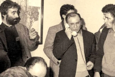 Ion Iliescu, în centru, vorbind la telefon. În stânga sa, Petre Roman. În dreapta lui, Adrian Sârbu
