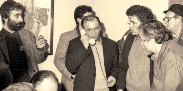 Ion Iliescu, în centru, vorbind la telefon. În stânga sa, Petre Roman. În dreapta lui, Adrian Sârbu