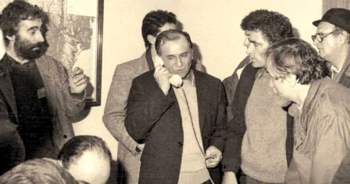 Ion Iliescu, în centru, vorbind la telefon. În stânga sa, Petre Roman. În dreapta lui, Adrian Sârbu