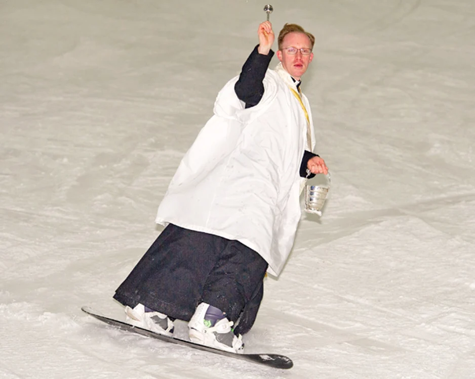 
    Vicarul britanic  Steven Young a citit  rugăciuni și a citit  din Biblie, pe  snowboard   