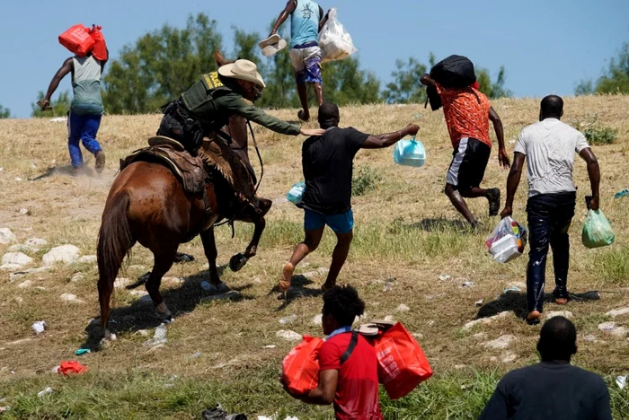 Agenti de poliţie de frontieră din Statelor Unite călare încearcă să opreasca un migranti haitian să intre într-o tabără pe malurile Rio Grande in Del Rio Texas