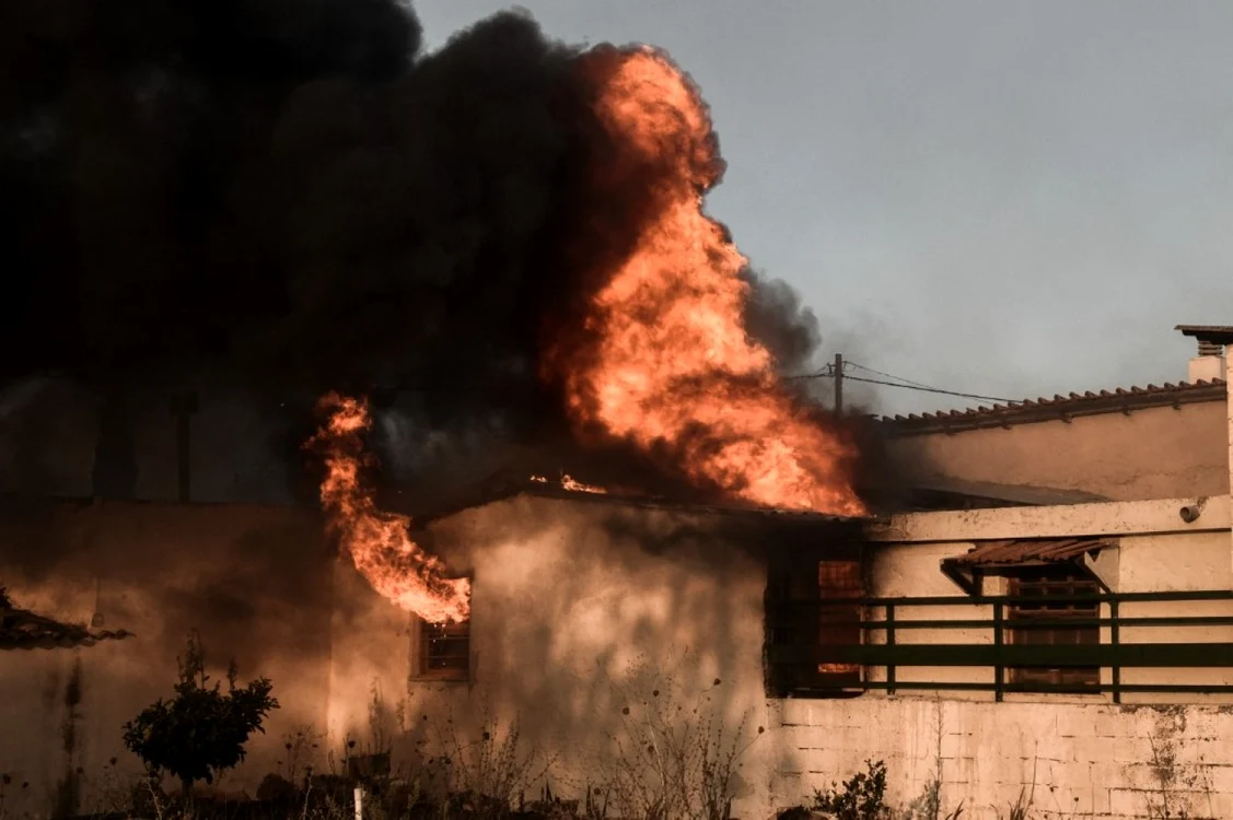 Flăcările mistuie o locuinţă din Penteli, o suburbie din nordul Atenei FOTO AFP