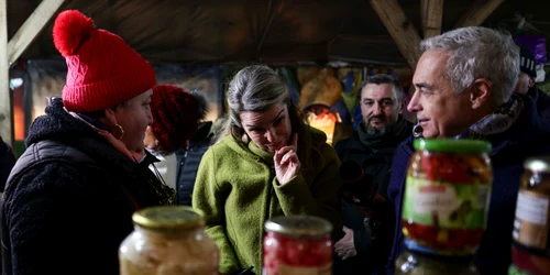 Călin Georgescu, însoțit de soția Cristela Georgescu, personal de pază și reprezentanți ai unui post de televiziune, face cumpărături în Piața 16 Februarie, în București. FOTO Inquam Photos / Octav Ganea