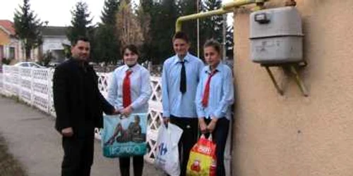 Elevii Carmen Ungureanu (stânga), şi Raul Rus (centru) şi Loredana Drugaş (dreapta) au donat cartofi pentru familiile nevoiaşe 