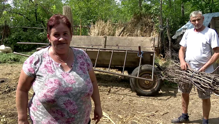 Cei doi soți pregătesc crengile pentru soba din bucătărie. FOTO Iulian Bunilă