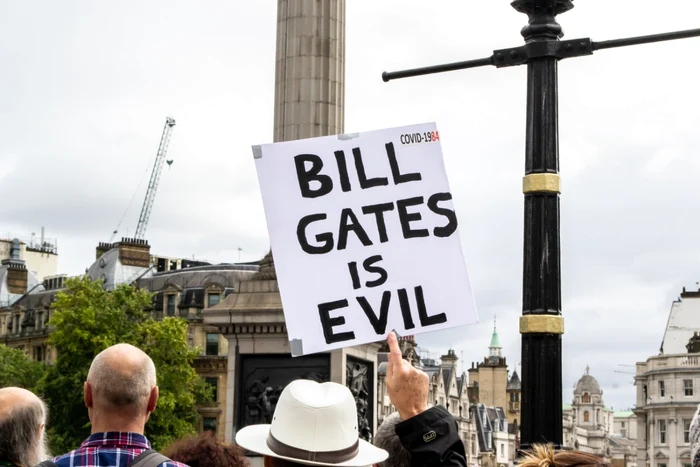 Un  bărbat poartă un banner cu „Bill Gates e malefic” la un protest la Londra FOTO SHUTTERSTOCK