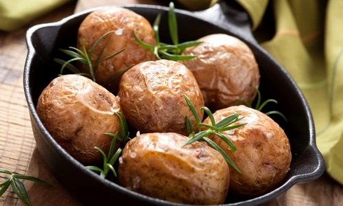 baked potatoes with rosemary in black pan jpeg