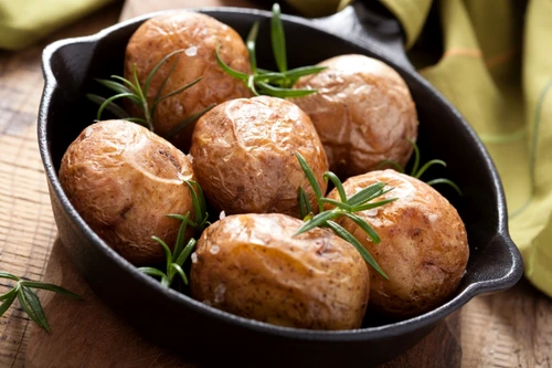 baked potatoes with rosemary in black pan jpeg