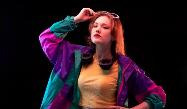 front view young modern woman colorful coat orange t shirt with black earphones sunglasses posing jpg