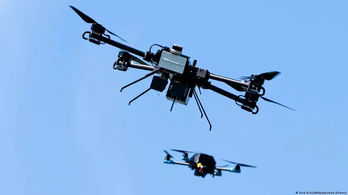 O dronă interceptoare urmărește o dronă mică pentru a o captura cu o plasă