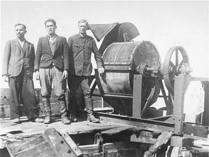 Members of a Sonderkommando 1005 unit pose next to a bone crushing machine in the Janowska concentration camp png png