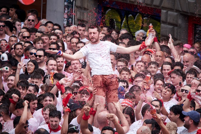 Publicul entuziast aruncă vin și flutură baticuri roșii (Foto: Profimedia)