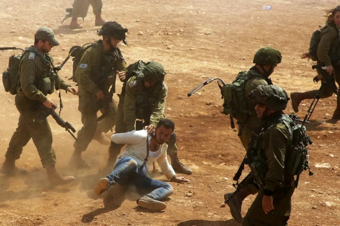 Soldații israelieni arestează un protestatar palestinian. FOTO AFP / Jaafar Ashtiyeh (arhivă)