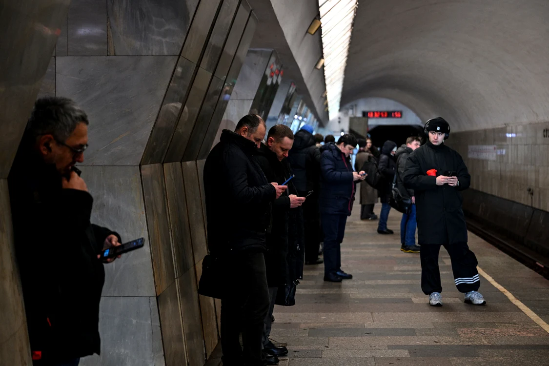 Ruși care își folosesc telefoanele în timp ce așteaptă metroul FOTO AFP