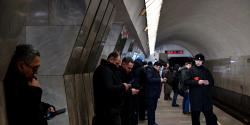 Ruși care își folosesc telefoanele în timp ce așteaptă metroul FOTO AFP