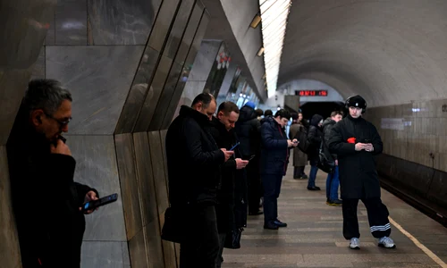 Ruși care își folosesc telefoanele în timp ce așteaptă metroul FOTO AFP