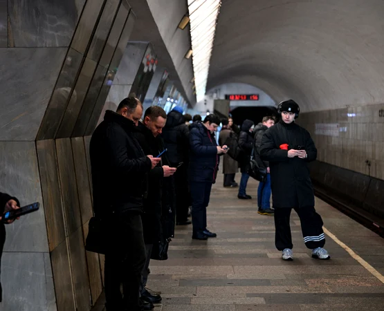 Ruși care își folosesc telefoanele în timp ce așteaptă metroul FOTO AFP