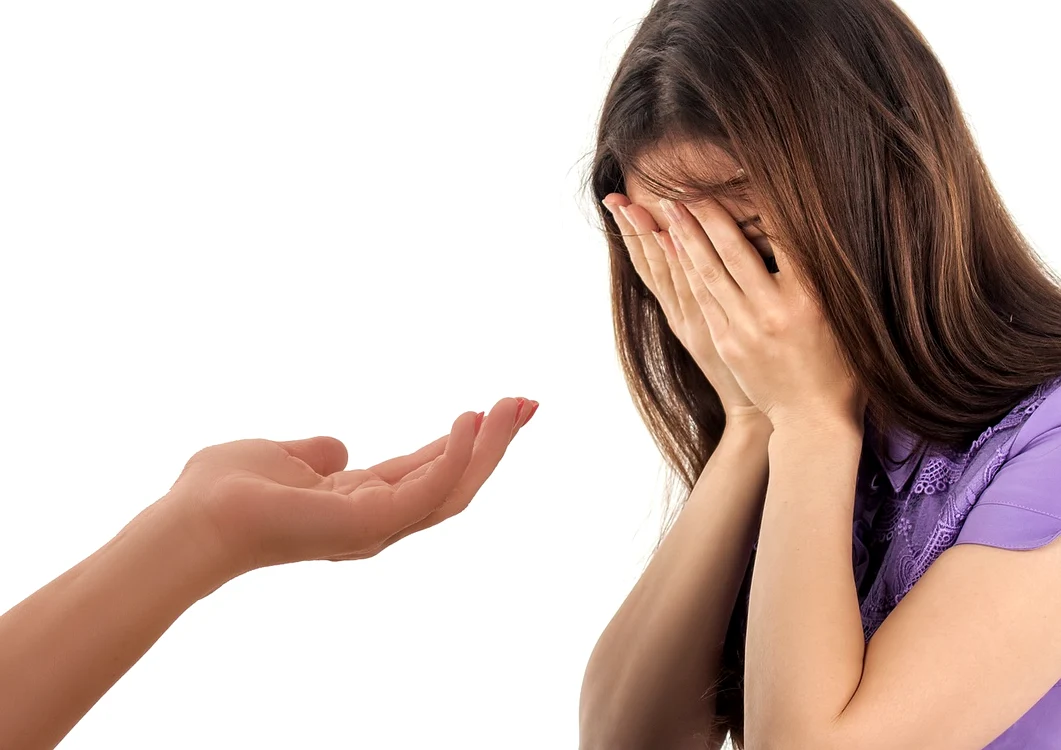 femeie îmbrăcată în mov cu mâinile duse la ochi, mână întinsă, ajutor