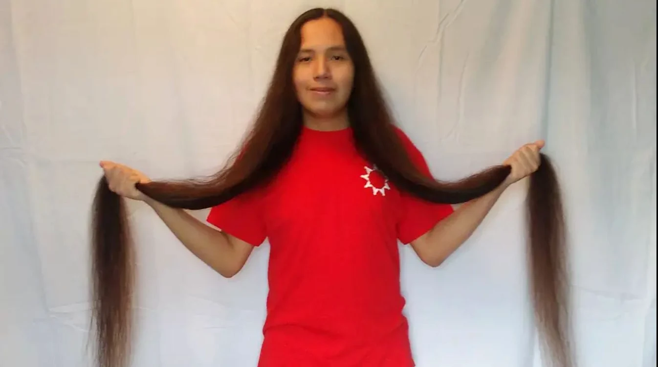 Reuben Looks Twice Jr., ținându-și în mâini părul record de 161 cm lungime