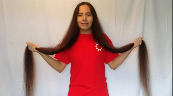 Reuben Looks Twice Jr., ținându-și în mâini părul record de 161 cm lungime
