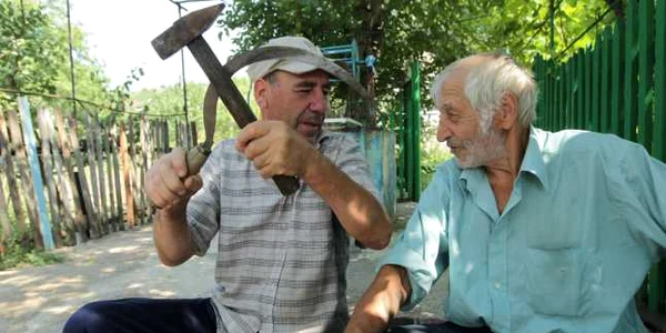 Nea Tudos Capcanari (dreapta) şi vecinul său Anatol Spiteţchi spun că au nevoie de seceră şi ciocan, la fel cum au nevoie comuştii de ele