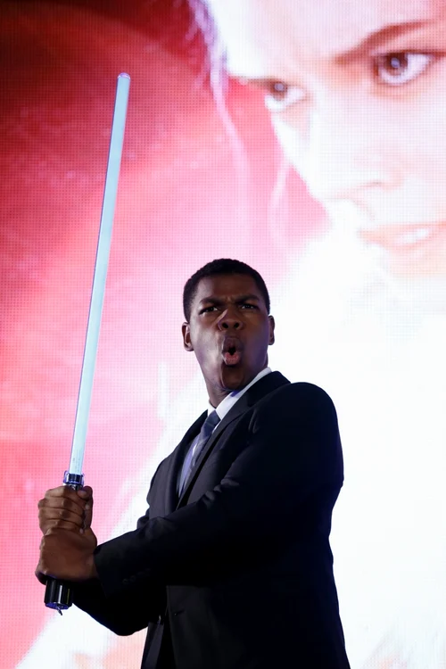 Actorul John Boyega pozează cu sabia laser la evenimentul dedicate fanilor Star Wars