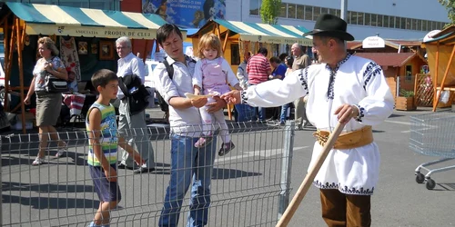 Badea Alexe ciopleşte lemnul cu o bardă mai bătrână decât el