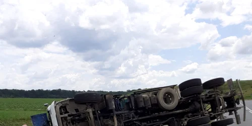 camion încărcat cu fier vechi răsturnat pe un drum din olt