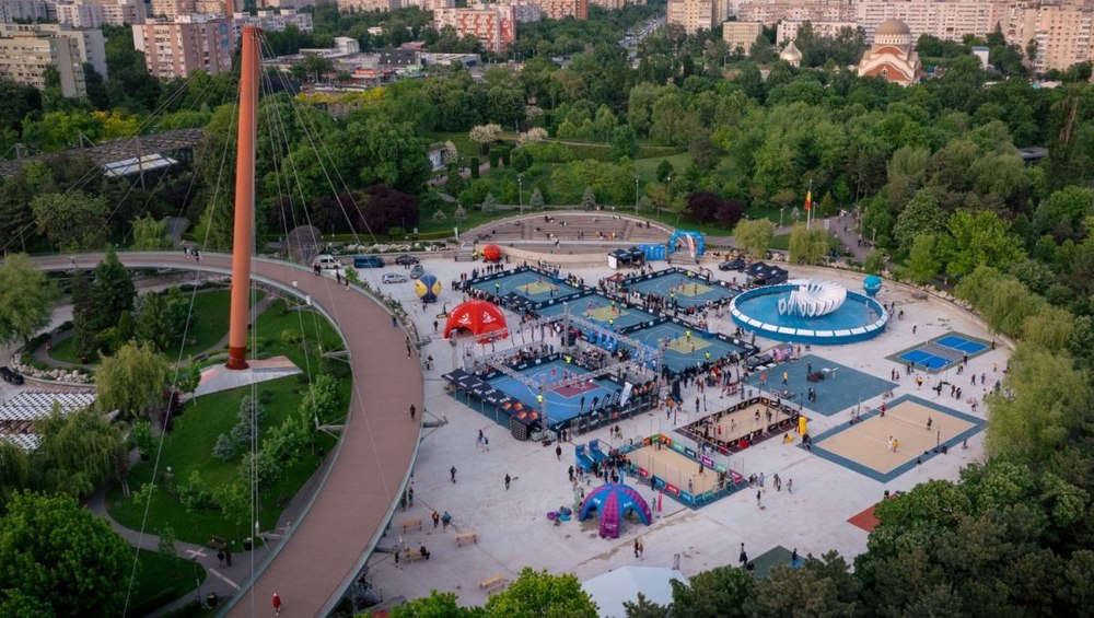 Tineri sportivi executând acrobații baschet pe terenul de baschet 3x3 în Parcul Drumul Taberei, lângă afiș cu campioni mondiali kendama. | sursa foto: Click