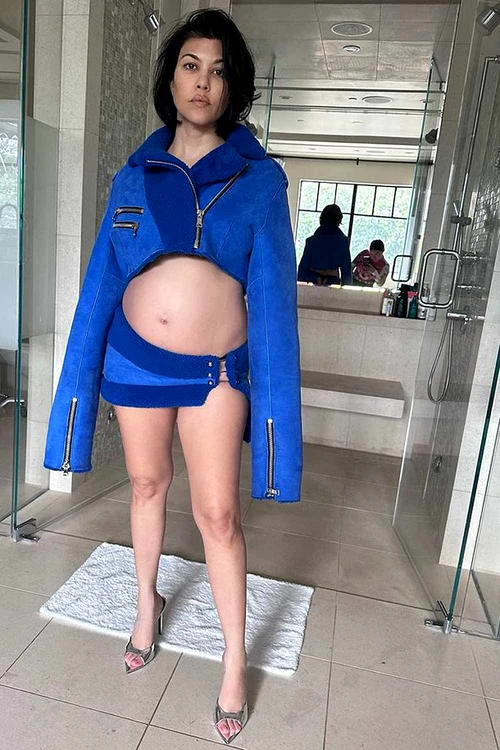 Kourtney Kardashian, îmbrăcată într-un compleu albastru, cu burta de gravidă expusă