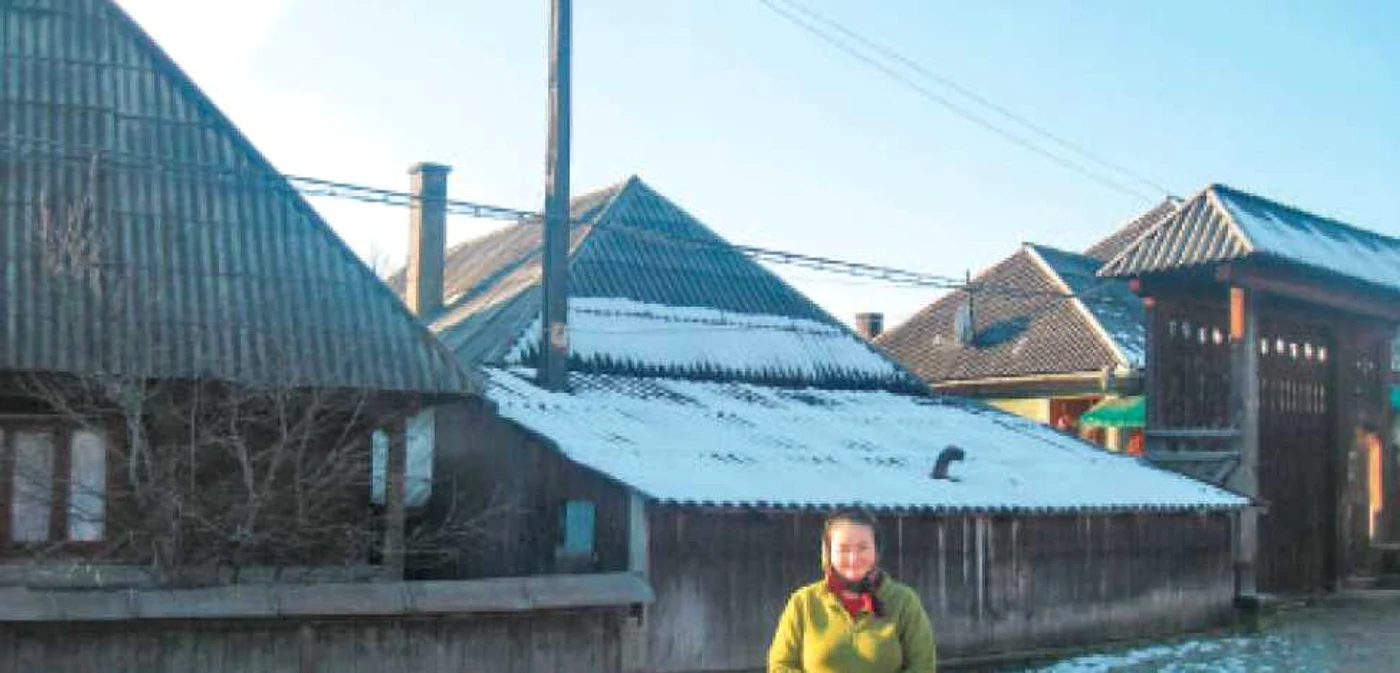 Mariana Bledea (29 de ani), în faţa casei construite în jurul stâlpului de electricitate 