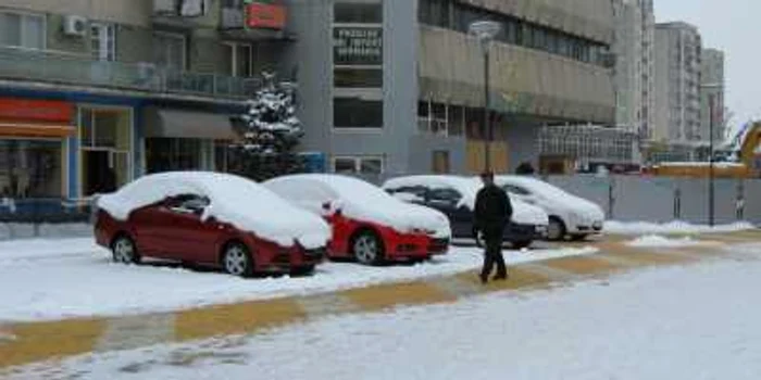 Maşinile expuse pe Strada Victoriei abia se văd de sub zăpadă