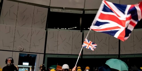 Un protestatar flutura steagul colonial britanic in cladirea parlamentului din Hong Kong FOTO AFP