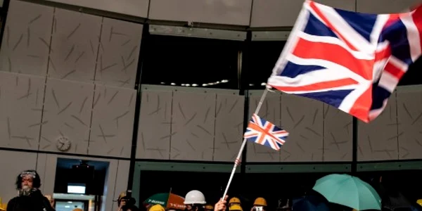 Un protestatar flutura steagul colonial britanic in cladirea parlamentului din Hong Kong FOTO AFP