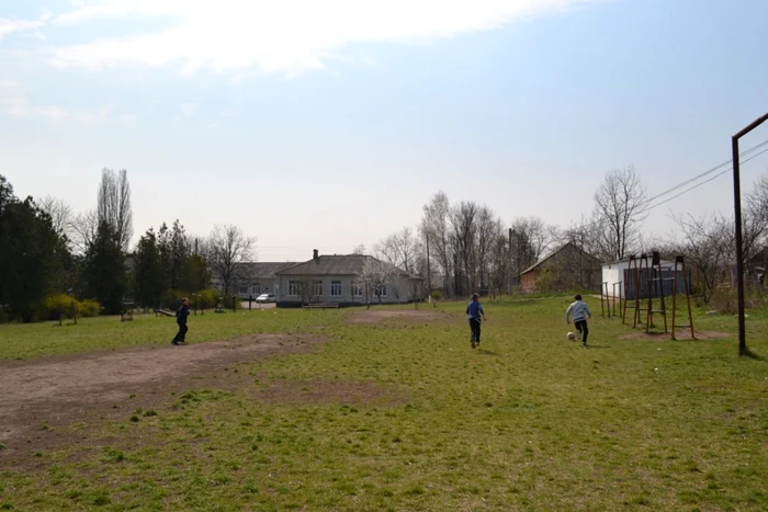 Câţiva băieţi bat mingea lângă şcoala din satul Egoreni, unde învaţă 57 de copii Fotografii: Olga Ceaglei