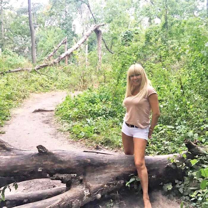 Cea mai discutată poză  între internauţi este cea  în care Udrea încearcă  să treacă peste trunchiul  unui copac căzut în pădure