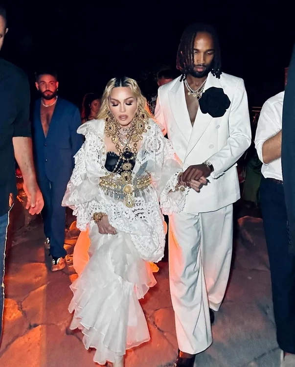 Madonna și Akeem Morris ținându-se de mână, amândoi îmbrăcați în alb. August 2024
