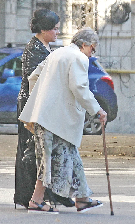 Mama artistului se deplasează ajutată de baston