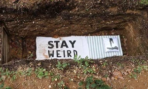 Pe cearșaful așezat pe fundul mormântului purificării scrie ”Rămâi ciudat” jpeg