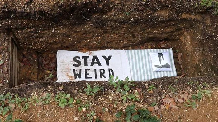 Pe cearșaful așezat pe fundul mormântului purificării scrie ”Rămâi ciudat”