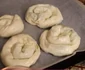 Se răsucesc sub formă de melc, apoi se pun în tavă. Nu uitați să puneți sub plăcințele și o hârtie de copt 