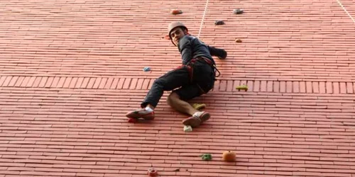 studenti care se catara pe camin