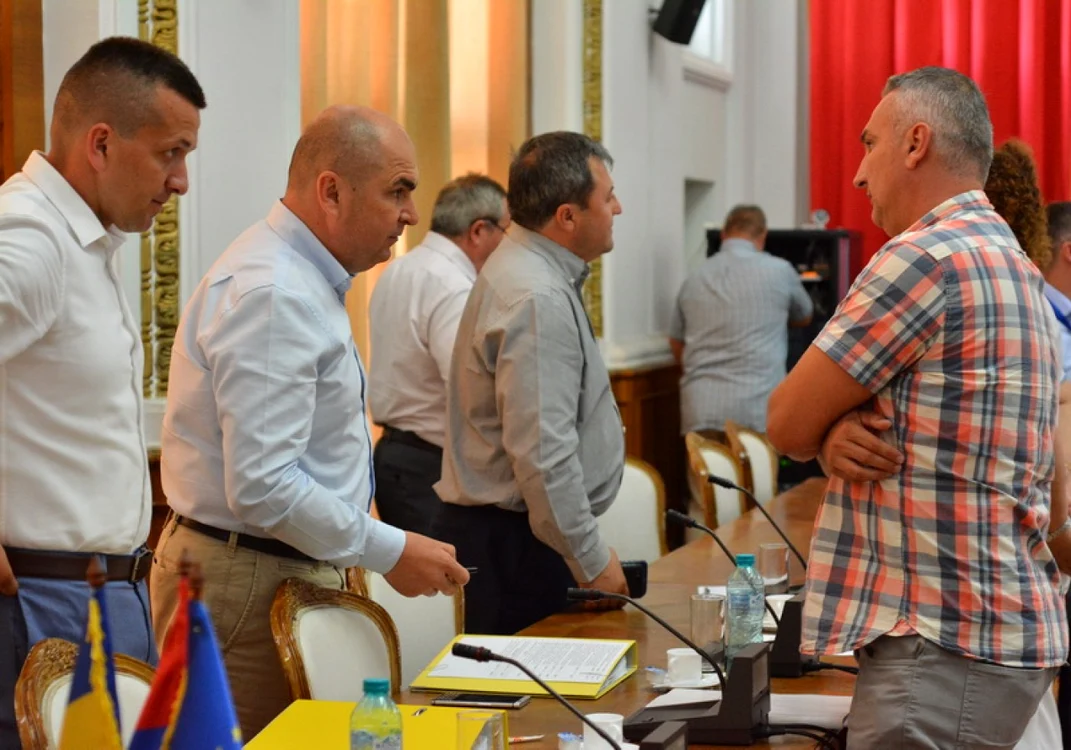 Primarul Ilie Bolojan (stânga) faţă în faţă cu unul dintre protestatari, în timpul şedinţei de consiliul local