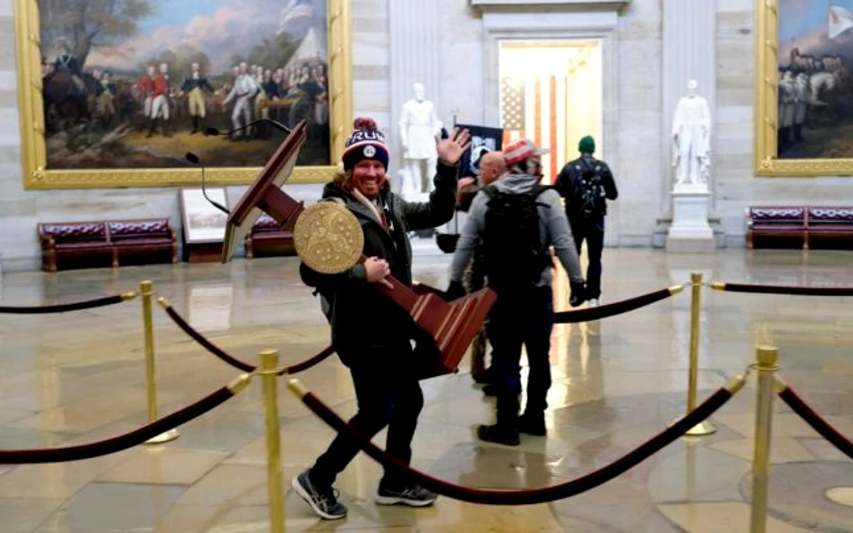 Adam Johnson, cărând pupitrul ornat cu aur al lui Nancy Pelosi în interiorul Capitoliului FOTO Twitter @NBCNews
