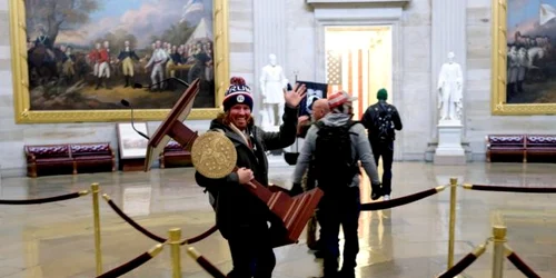 Un barbat carand un pupitru ornat cu aur in interiorul Capitoliului FOTO Twitter @NBCNews